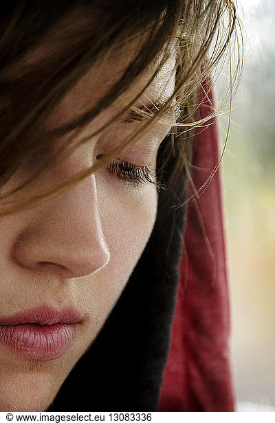 Close-up of thoughtful woman with brown hair looking down
