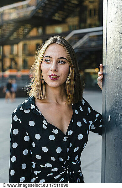 Close-up of thoughtful young woman looking away while standing in city