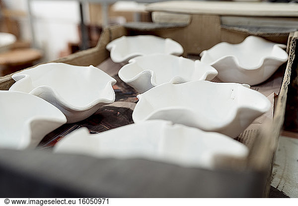 Close-up of unfinished clay containers on table in workshop