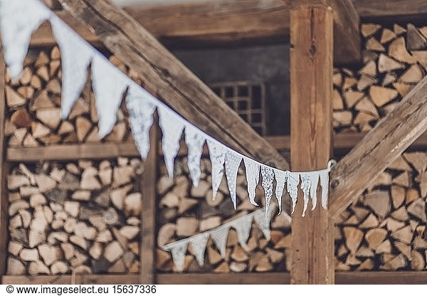 Close-up of white buntings hanging against firewood in yard at wedding party