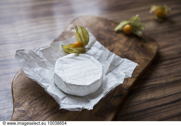 Close-up of white cheese and gooseberry on chopping board  Germany