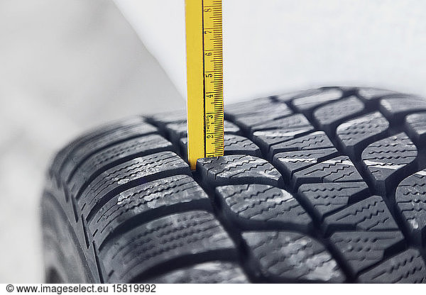 Close-up of winter tire being checked
