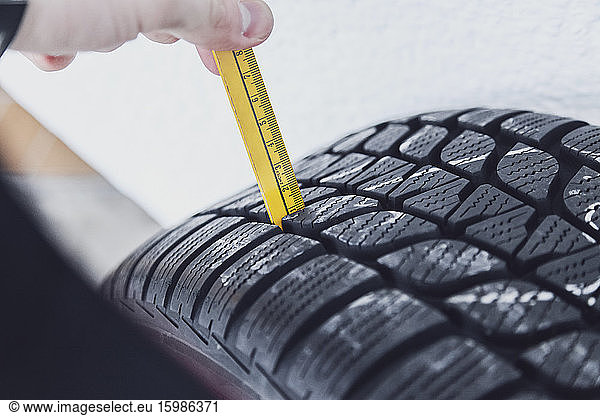 Close-up of winter tire being checked