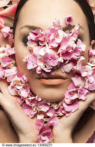 Close-up of woman face covered with flower petals