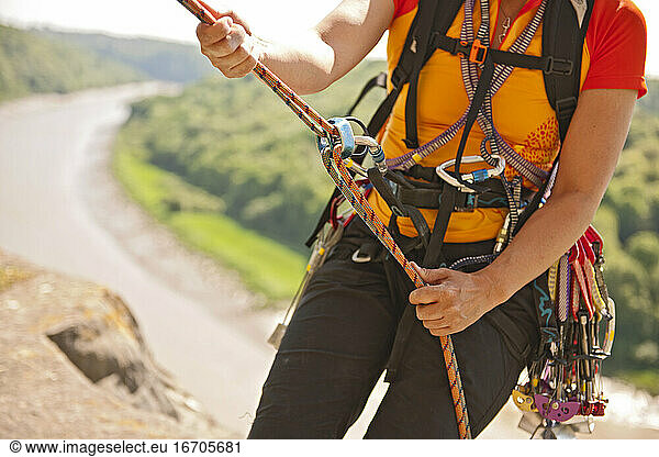 close up of woman rappelling of cliff in south Wales
