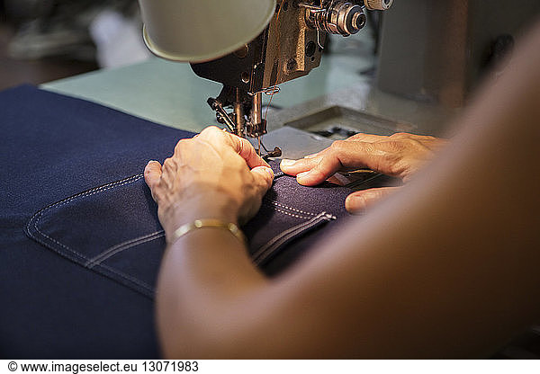 Close-up of woman sewing in textile factory