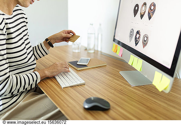 Close-up of woman using desktop pc for online shopping at home