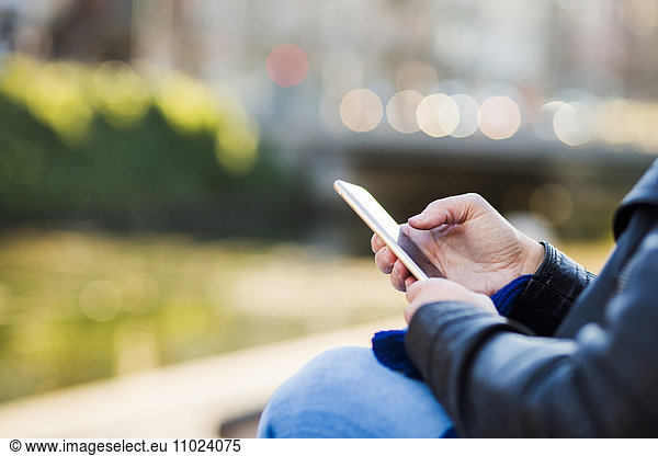 Close-up of woman using smart phone while waiting for friend