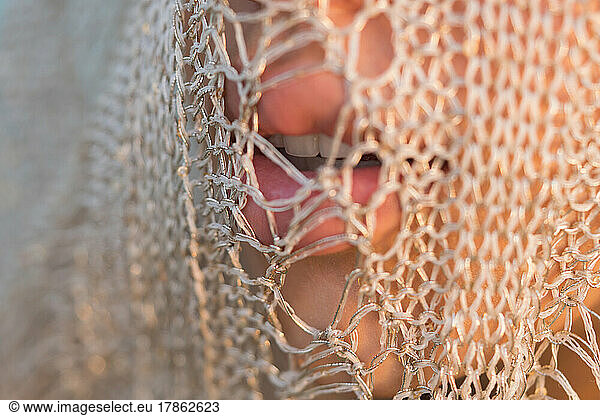 Close up of women lips under golden net