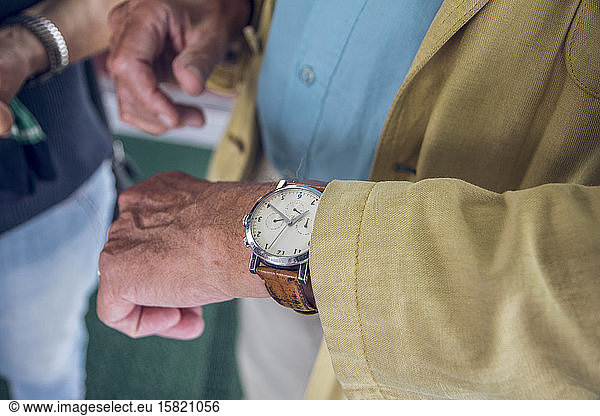 Close up of wrist watch  senior man checking the time