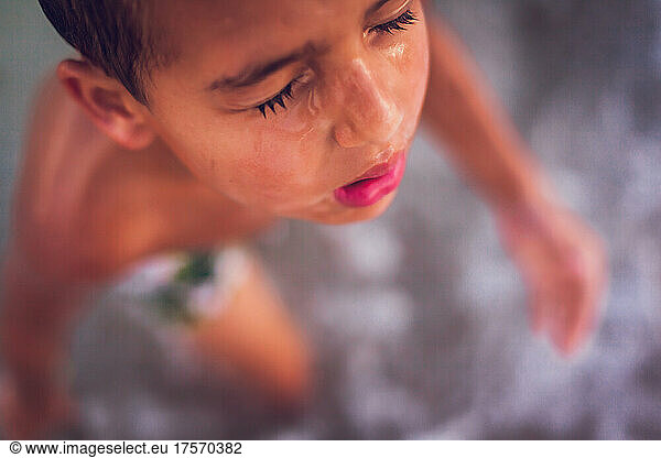 Close up of young boy coming out of the ocean