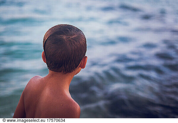 Close up of young boy looking at the ocean