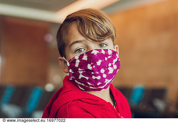 Close up of young boy wearing a mask at airport.