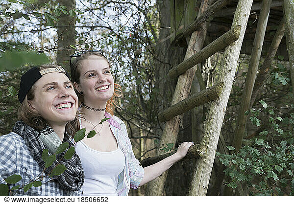 Close-up of young couple standing with ladder of lookout tower and smiling  Bavaria  Germany