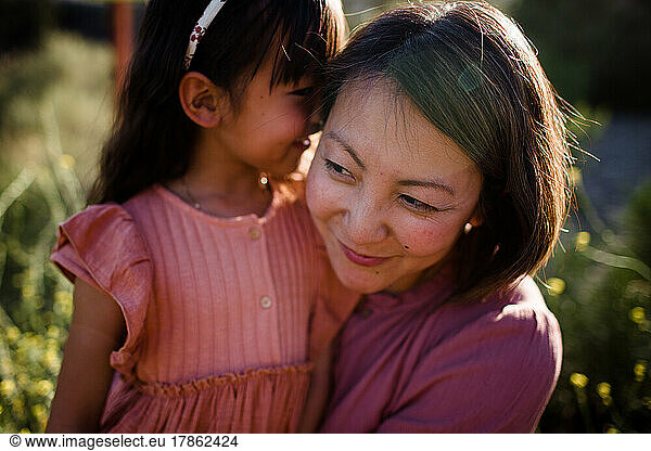 Close Up of Young Girl Whispering to Mom at Sunset in San Diego
