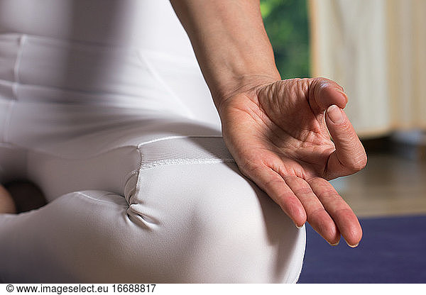 Close up on the hands of a woman sitting and meditating