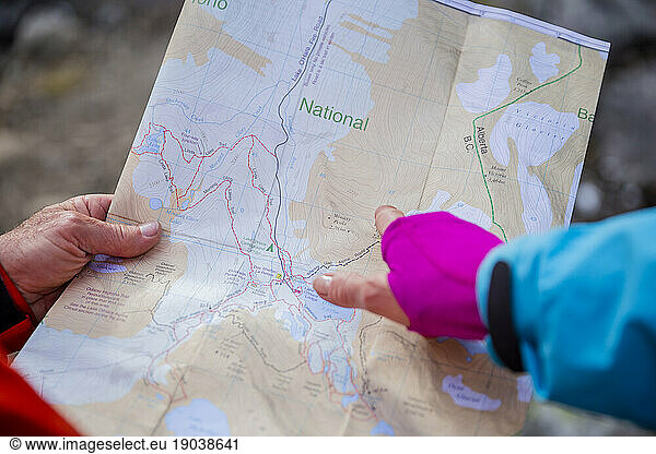 Close up photo of the hiker pointing to a place on the paper map