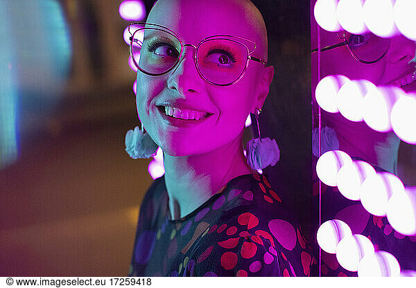 Close up portrait beautiful woman with shaved-head  head by neon light