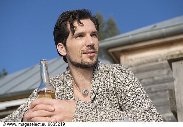 Close up portrait man holding beer bottle
