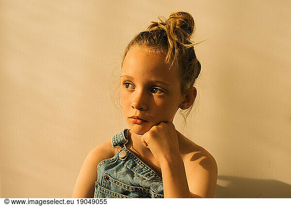 close up portrait of a young girl with freckles and dungarees