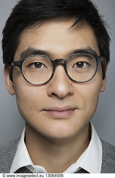 Close-up portrait of businessman against gray background