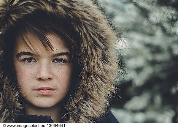 Close-up portrait of confident boy wearing fur coat during winter