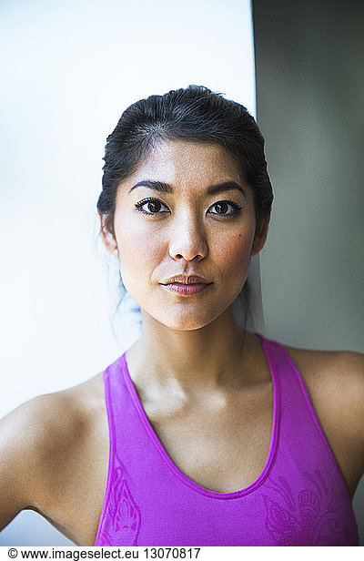 Close-up portrait of confident sporty woman at home