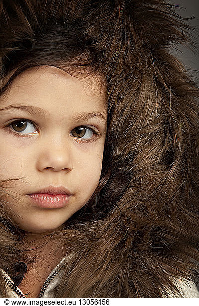 Close-up portrait of cute girl wearing brown fur hood