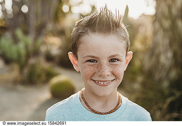 Close up portrait of cute young boy with freckles smiling