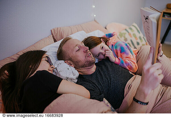 close up portrait of father reading to his daughters
