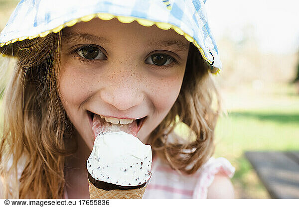 close up portrait of girl with freckles eating ice cream