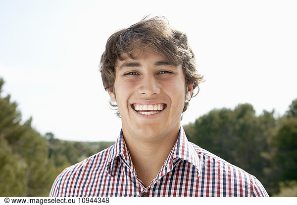 Close up portrait of handsome young man smiling outdoors