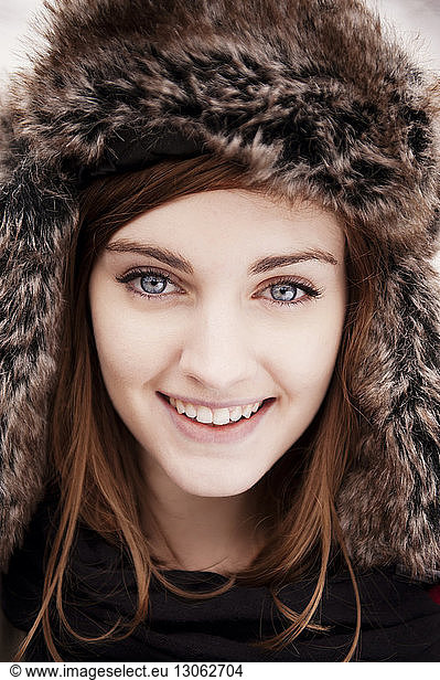 Close-up portrait of happy woman wearing fur hat