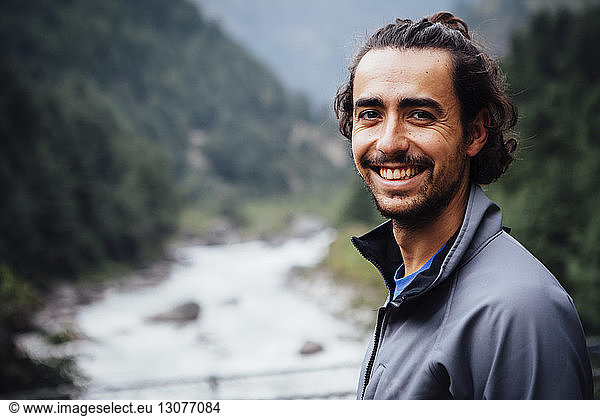 Close-up portrait of smiling man standing by river at Sagarmatha National Park