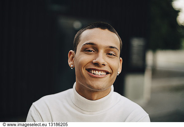Close-up portrait of smiling young man wearing turtleneck