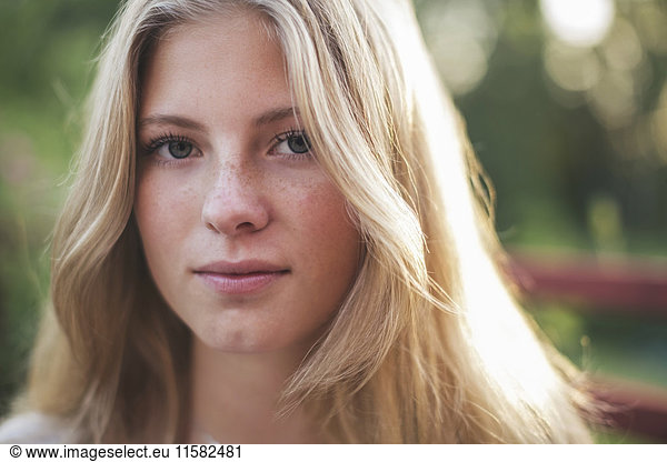 Close-up portrait of teenage girl in back yard