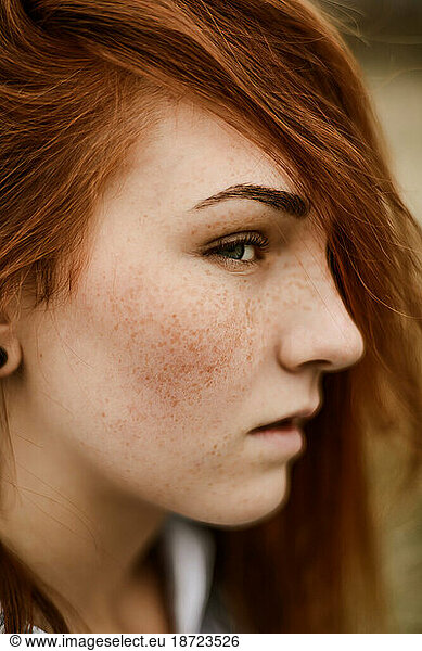 Close-up portrait of teenage girl with red head