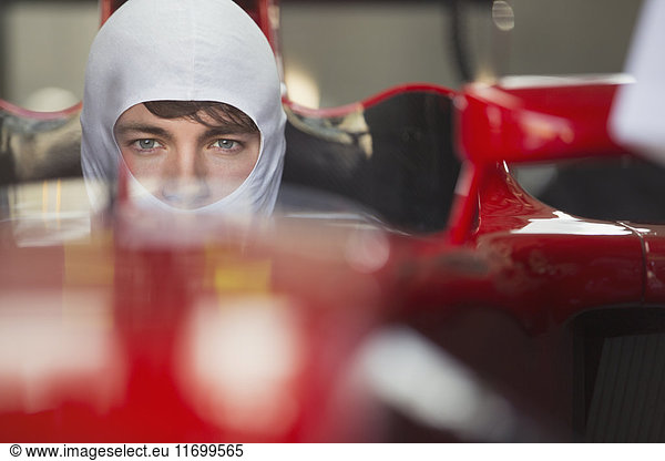 Close up portrait serious formula one race car driver wearing protective mask