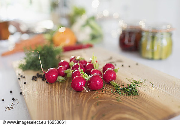 Close up red radishes and herbs on cutting board