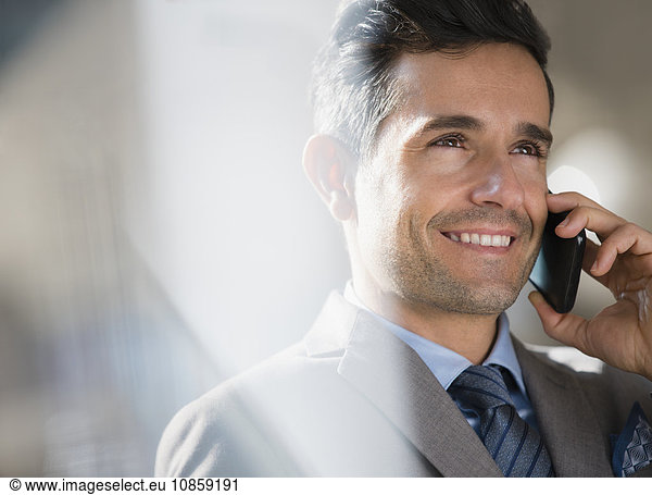Close up smiling corporate businessman talking on cell phone