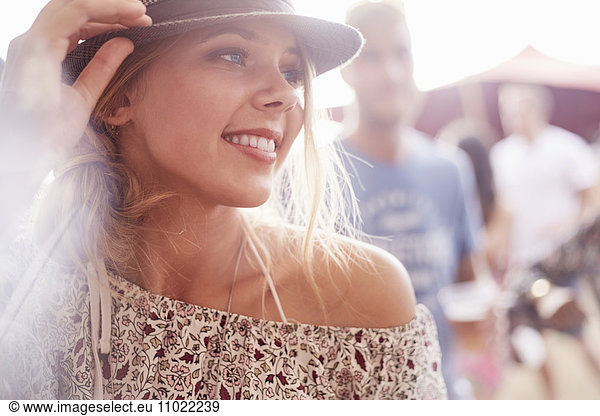 Close up smiling young blonde woman at music festival