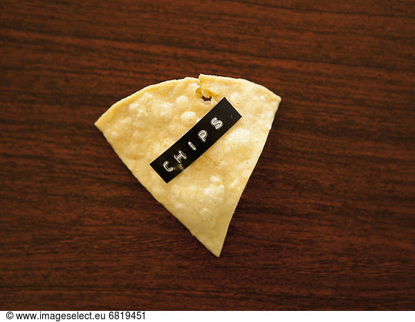 Close-up view of nacho chip with label reading chips