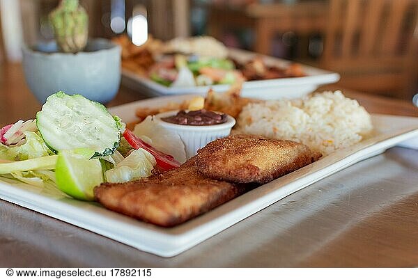 Close up von gebratenem Fischfilet mit Reis und Salat auf dem Tisch mit Kopie Raum serviert. Gourmet-Food gebratenes Fischfilet mit Salat Reis auf Holztisch serviert  Gourmet-Food gebratenes Fischfilet