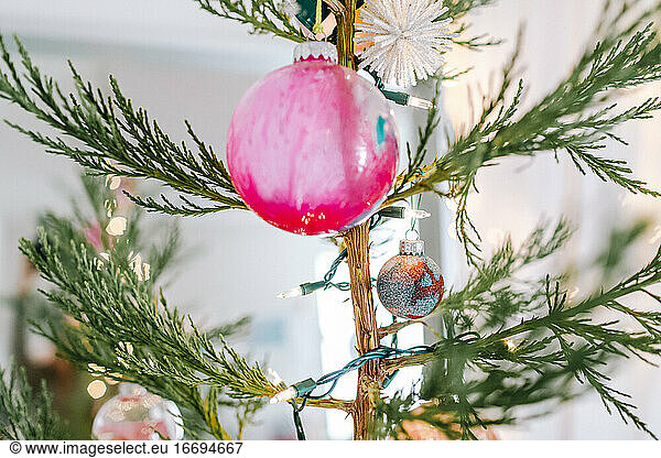 Close up von rosa hausgemachten Glas Ornament der natürlichen Weihnachtsbaum und Licht