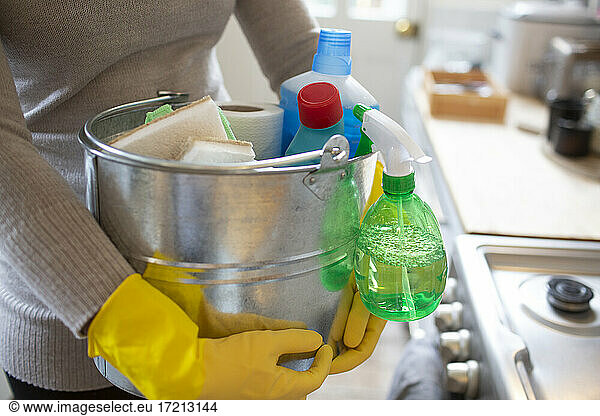 Close up woman in rubber gloves with cleaning supplies