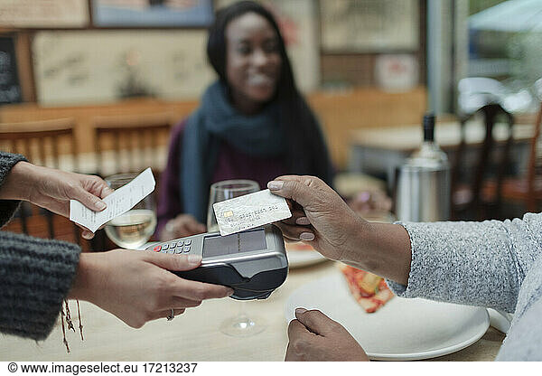 Close up woman paying waitress with smart card