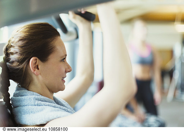Close up woman using exercise equipment at gym