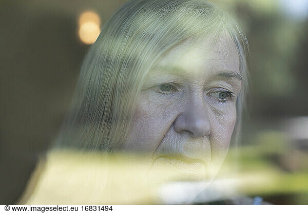Close up worried senior woman at window