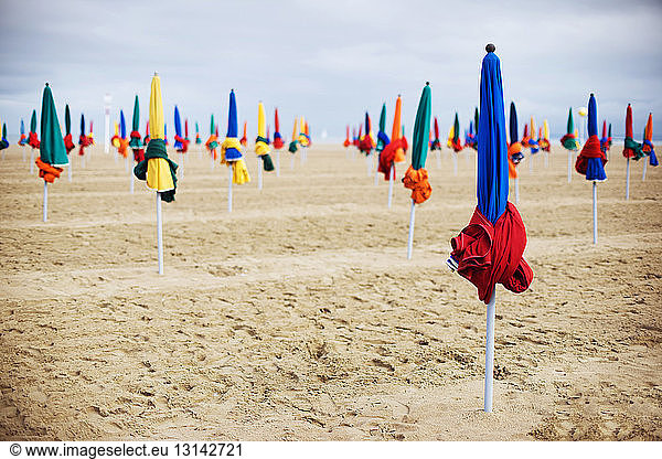 Closed parasols on sand at beach