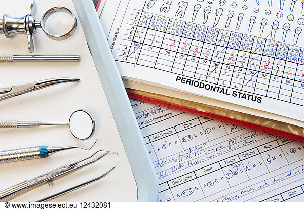 Closeup of dental tools and dental records in a dental office.